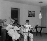This is from Christmas 1964, when my parents thought it would be great for my brother & myself to play Christmas songs. I am on the violin, and my brother is on the clarinet. Each of our sheet music was apparently in a different key. You can guess how it sounded ;-) but it made our parents happy. Neither of us continued to play music more than a few more years, but it did give us an appreciation of the effort involved to play good music, let alone great music. - Carol