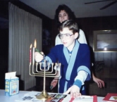 My youngest stepson and me, lighting the Hanukkah candles. We celebrate both holidays at our house as I was raised Jewish and they  always had Christmas. The boys liked lighting the candles. - Dana W