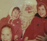 This must be 1964.  My favorite memory was going to the city of Grand Rapids MI during the Christmas season with my parents and my sisters (before the boys were born).  We would be all bundled up all snuggly in our  best church coat and mufflers and we would walk all over downtown looking in the store windows enchanted by the moving dolls Christmas display.  Then we would go to the dept store and get our pics taken.  I am the one in the white hat!  To this day I always liked a man with a beard and mustache and presents :)  Merry Christmas! - Kathleen M